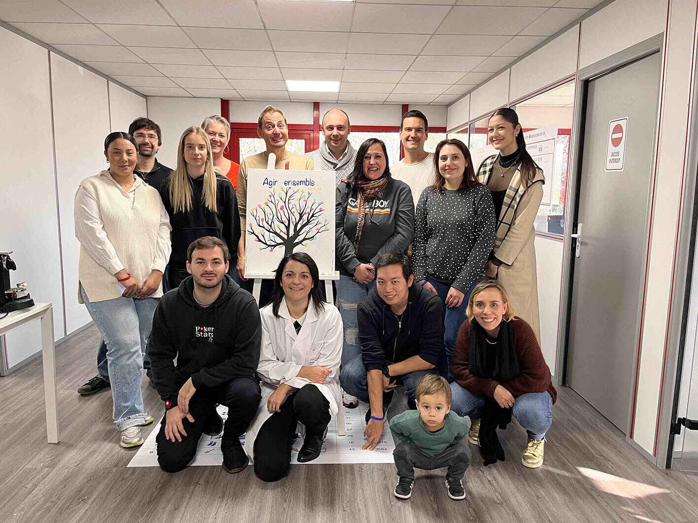un groupe pose pour la photo avec un tableau agir ensembe
